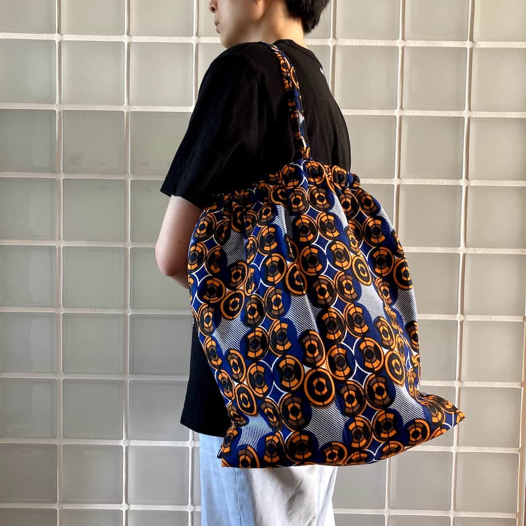 ワックスプリント巾着型バッグ - ORANGE CIRCLE - Borderless Creations